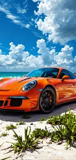 Orange supercar on a beach with clear skies and ocean view.