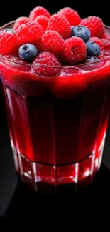 Refreshing glass of berry juice with raspberries and blueberries.