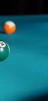 Teal billiard table with colorful scattered balls.