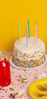 Birthday cake with colorful candies and partyware.