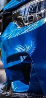 Close-up of a vibrant blue car showing sleek design and reflections.