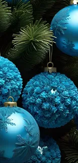 Blue Christmas ornaments on green pine branches.