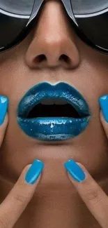 Vibrant blue lips and nails with sunglasses on mobile wallpaper.