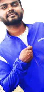 Man in a vibrant blue jacket posing confidently.