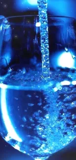 Close-up of blue water being poured into a glass with vibrant lighting.