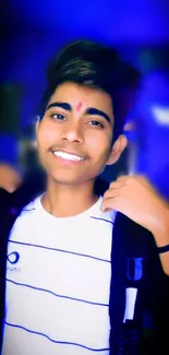 Portrait of a smiling young man with vibrant blue background.