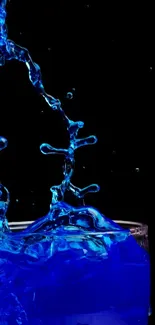 Blue water splash on a dark background, creating a dynamic and artistic effect.