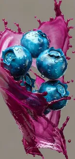 Vibrant splash of pink liquid with blueberries in artistic design.