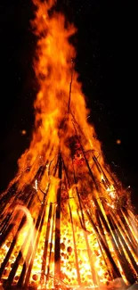 Fiery bonfire blazing under a dark sky creating a vibrant effect for phones.