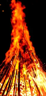 Fiery bonfire with vibrant flames on a mobile phone wallpaper.