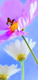 Butterfly rests on vibrant flowers against a blue sky background.