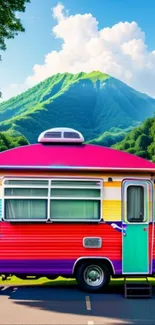 A colorful camper against a mountain backdrop.