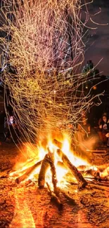 Vibrant campfire with sparks illuminating the night sky.