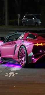 Sleek neon pink sports car on city road at night.