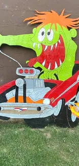 Cartoon car art with green monster driver on brick wall.