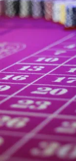 Close-up of a magenta casino table with numbered betting areas.