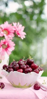 A bowl of cherries with pink daisies on a vibrant wallpaper.