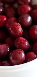 Juicy red cherries in a white bowl.