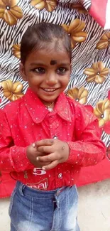 Joyful child in red shirt with floral background.