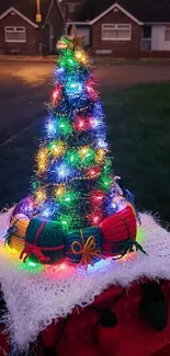 Festive Christmas tree with colorful lights in a suburban evening setting.