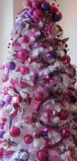 Vibrant Christmas tree with pink and purple decorations.