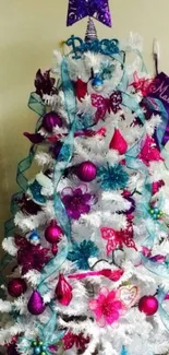 Festively decorated white Christmas tree with colorful ornaments.