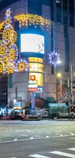 A vibrant urban street adorned with festive holiday lights at night.