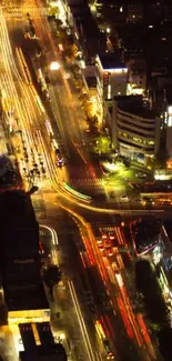 A vibrant city street at night with bright lights and bustling traffic.