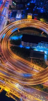 Aerial view of vibrant city lights at night with glowing highways and buildings.