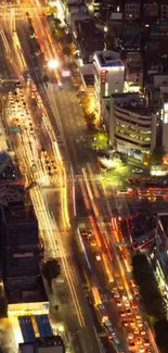 Aerial view of city streets with vibrant night lights and bustling traffic.