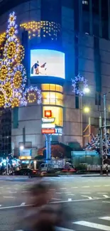 Festive city street with bright lights and decorations at night.