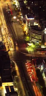 Aerial view of a vibrant city intersection at night with illuminating lights.