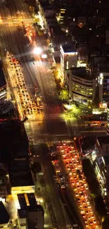 Bustling city streets illuminated by vibrant night lights viewed from above.