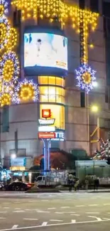 City street illuminated with festive lights and decorations at night.