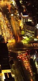 Aerial view of a city's illuminated streets at night with busy traffic.