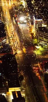 Aerial city view at night with vibrant lights and busy traffic.