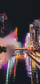 Colorful city skyline at night with vibrant river reflections.