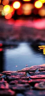 Blurry city night reflections with vibrant lights on wet cobblestones.