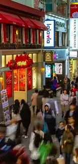 Vibrant city street at night with shops and crowds