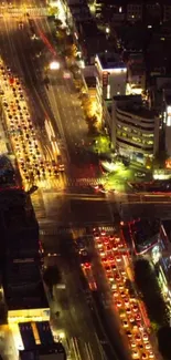 Aerial view of a vibrant city intersection at night with bustling traffic.