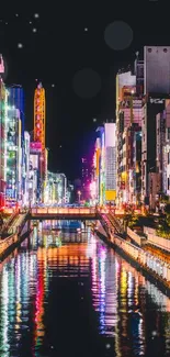 Vibrant city at night with neon reflections on the water.