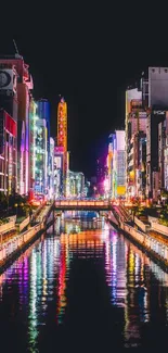 Vibrant city nightscape with colorful neon lights reflected in a river.