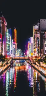 Vibrant city nightscape with colorful neon lights reflecting on a canal.