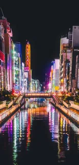 Vibrant city with colorful night lights reflecting on a canal.