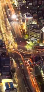 Overhead view of a vibrant city at night with trailing traffic lights.