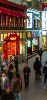 Busy city street with colorful shops and people at night.