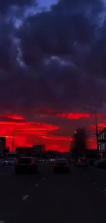 City skyline under a vibrant red sunset, framed by dramatic clouds.