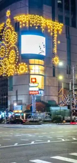 Nighttime city scene with glowing holiday lights and decorations on buildings.