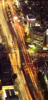 Aerial view of city at night with bright light trails and illuminated skyscrapers.