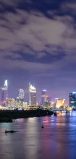 City skyline at night with reflections over water.